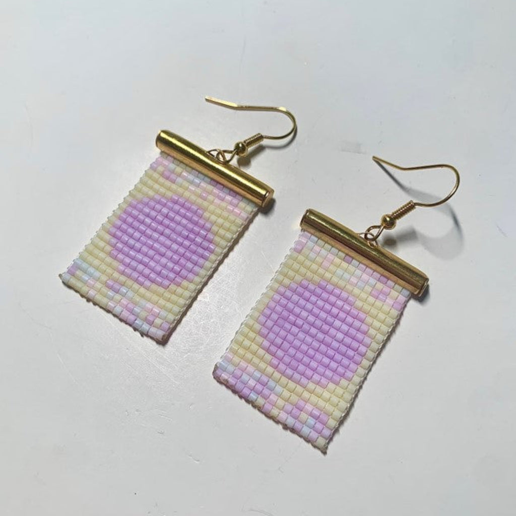 Pair of beaded earrings with gold hooks on a light gray background